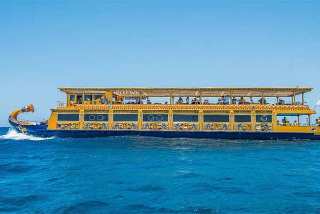 ourists inside Nefertari Submarine in Marsa Alam watching colorful coral reefs and Red Sea marine life.